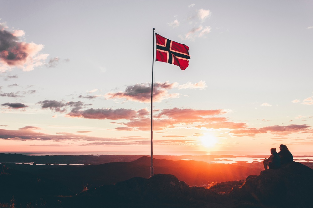 Flytta till Norge, norsk flagga i solnedgång